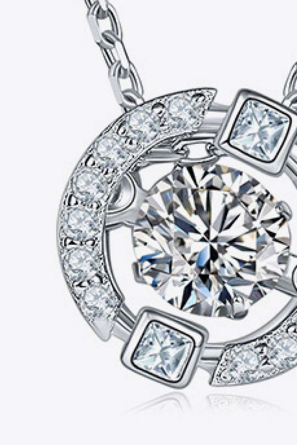 Enlarged detail of the round moissanite center stone and silver pendant setting.