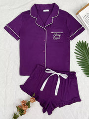 Purple button-down pajama set with white piping and matching ruffle shorts, front view