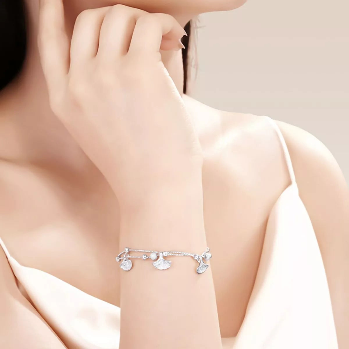 Silver ginkgo leaf bracelet worn on wrist in a close lifestyle photo