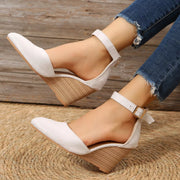 White pointed-toe sandals shown in profile with wedge heels