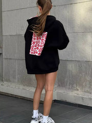 Back view of black oversized hoodie with rectangular red lip-print panel
