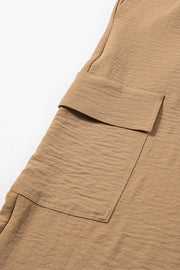 Close-up of the flap cargo pocket on tan utility trousers