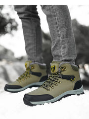Olive green and black lace-up ankle boots with yellow accents, front view in snow