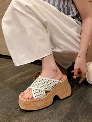 Side view of a cream woven cross-strap sandal with a thick cork-look platform