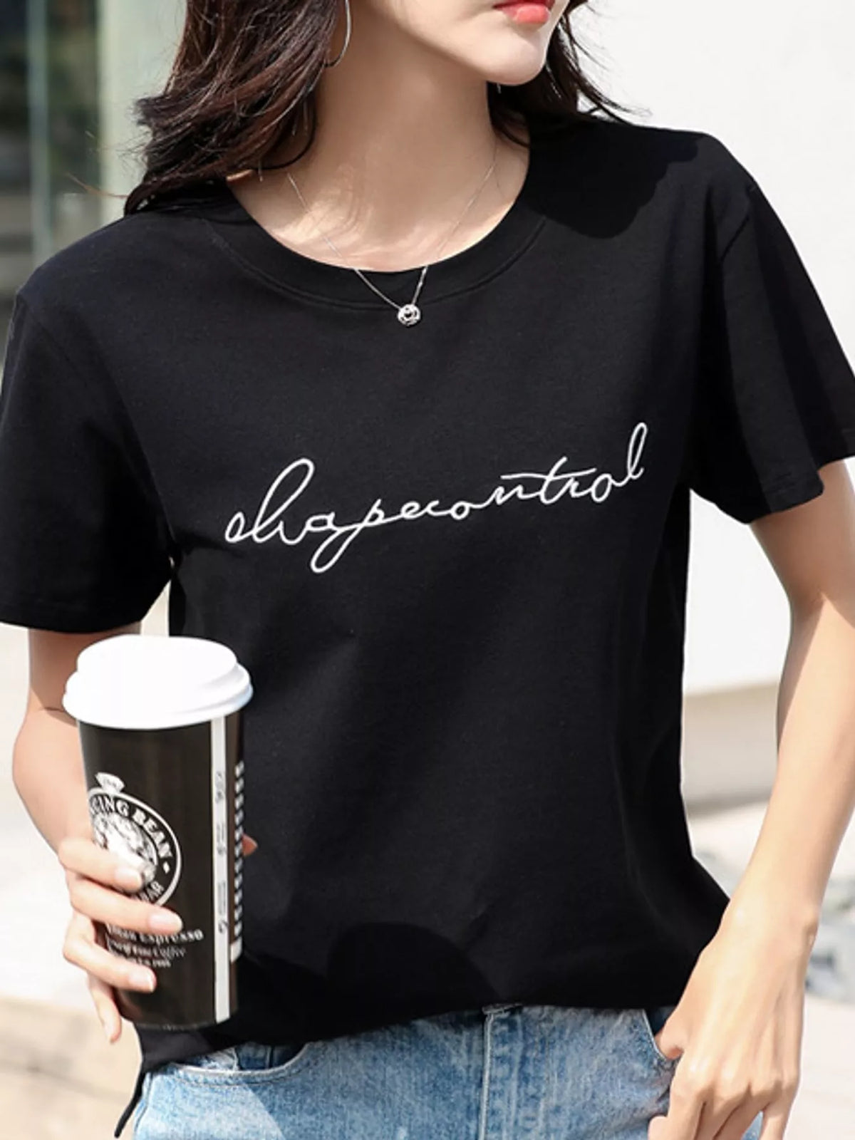 Model wearing a black crew-neck T-shirt with embroidered script lettering
