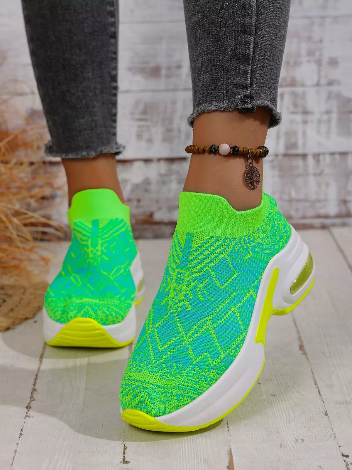 Angled side view of lime green trainers showing patterned mesh and a gold-coloured heel insert