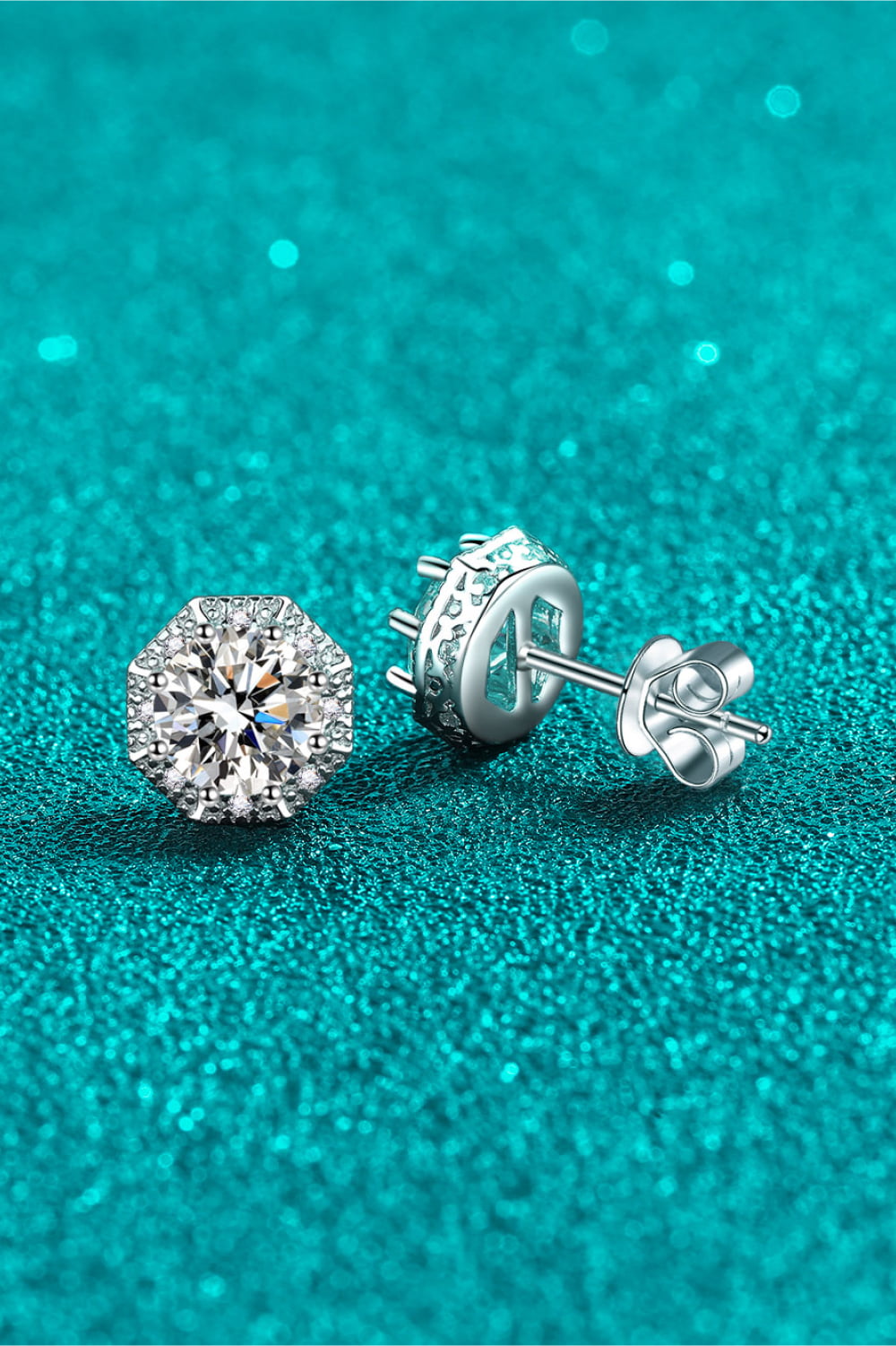 Close-up of moissanite stud and butterfly back on teal background
