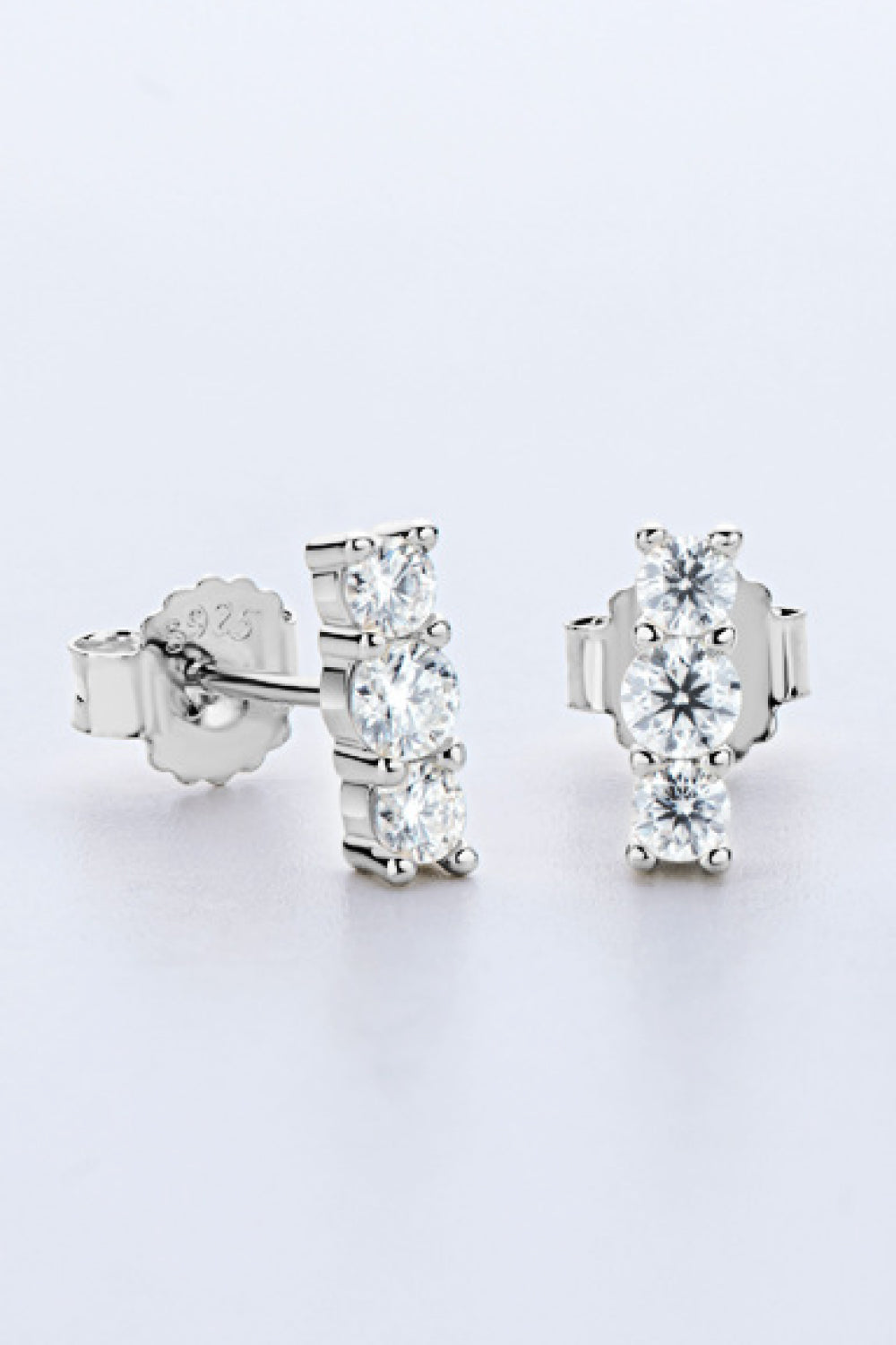 Pair of three-stone moissanite studs, front and side view