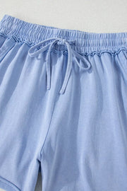 Close-up of gathered elastic waistband and drawstring on blue shorts