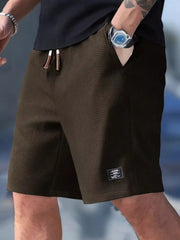 Dark brown waffle-textured shorts with drawstring waist and side pockets on a model