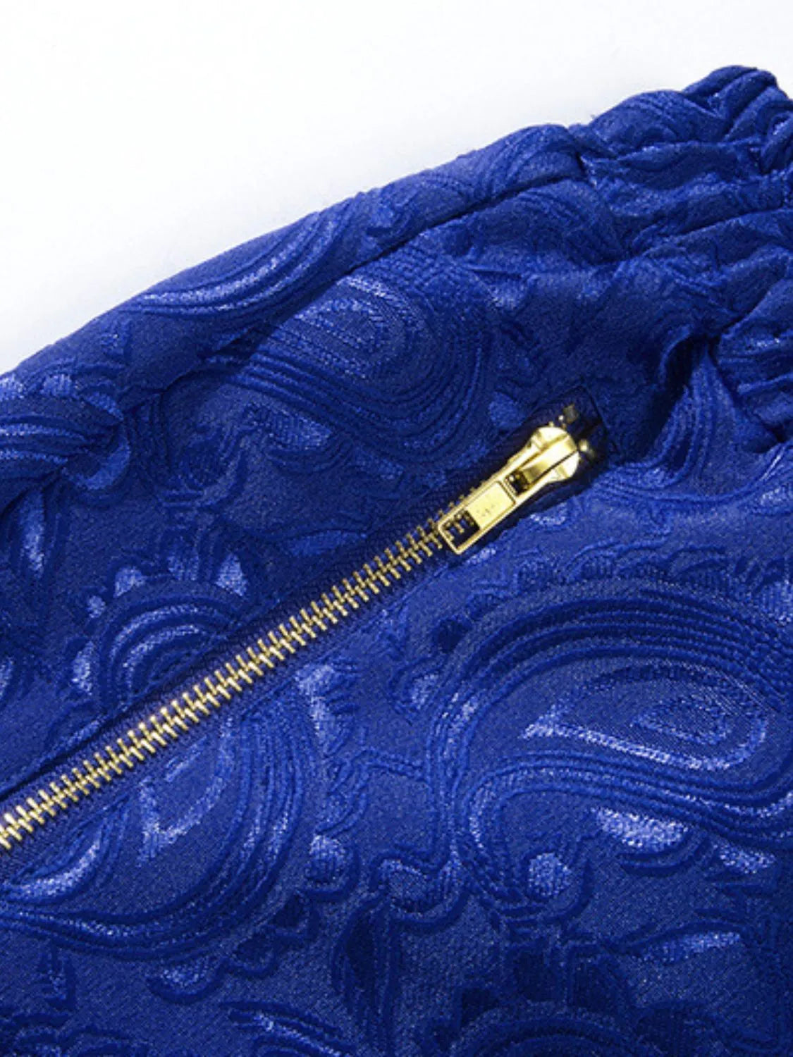 Close-up of blue paisley fabric and gold-tone zipper