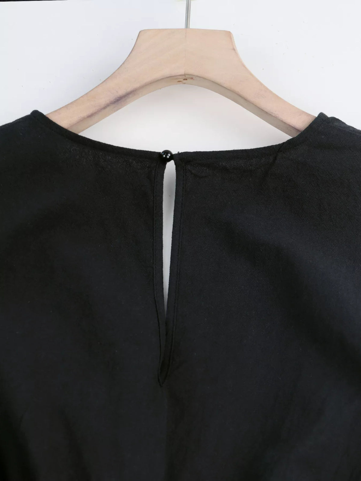 Back neckline detail with button closure