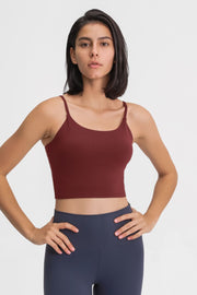 Front view of a model in a burgundy scoop-neck cami and navy leggings.