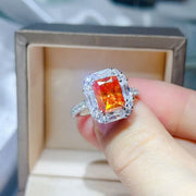 Orange halo ring held between fingers for a close-up