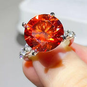 Orange-red centre-stone moissanite ring worn on hand