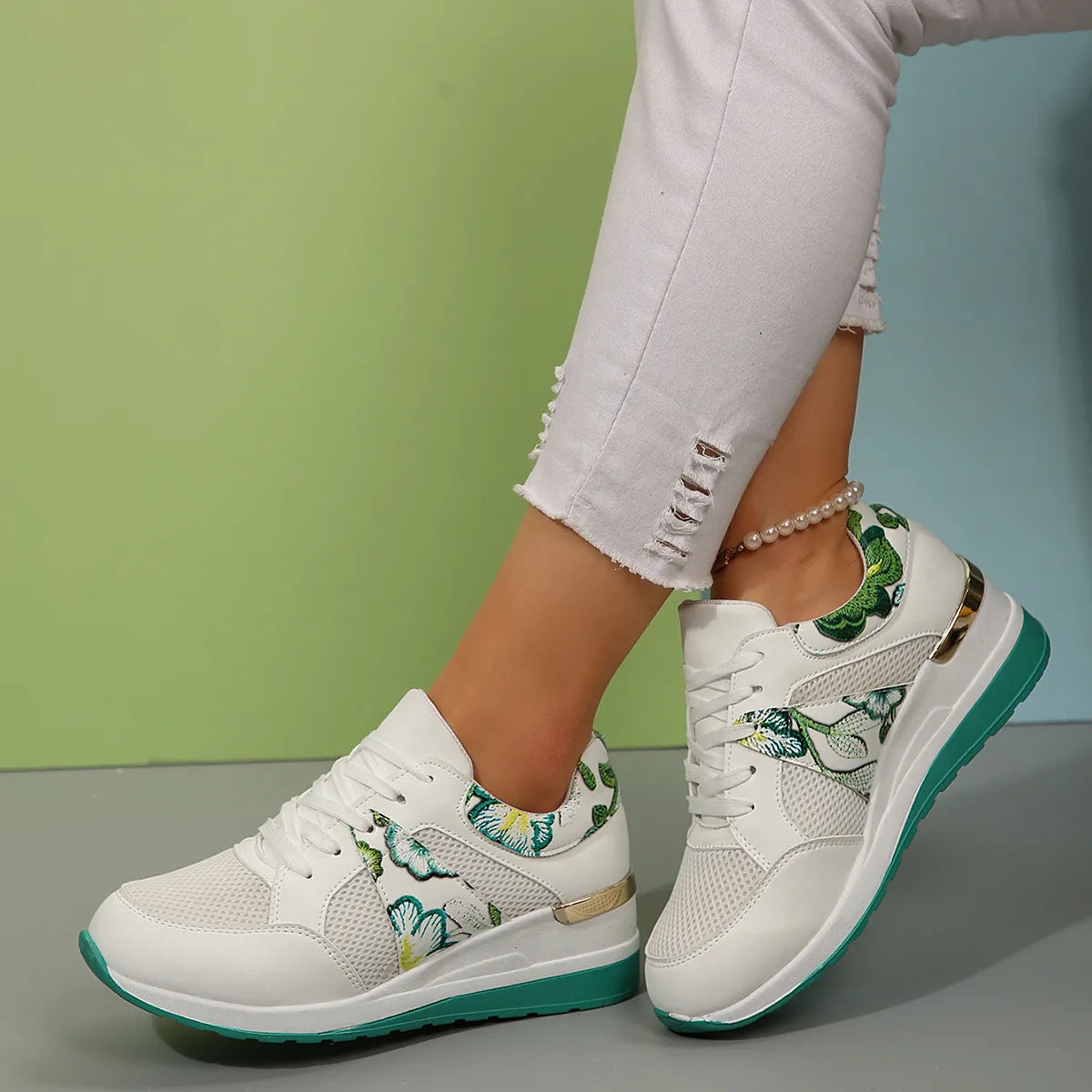 White sneakers with green floral panels worn from the side