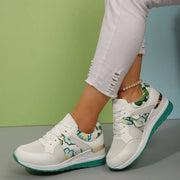White sneakers with green floral panels worn from the side