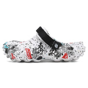 Side profile of a white graffiti-print clog with a black instep strap