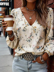 Model wearing cream floral V-neck blouse with gathered sleeves, street setting