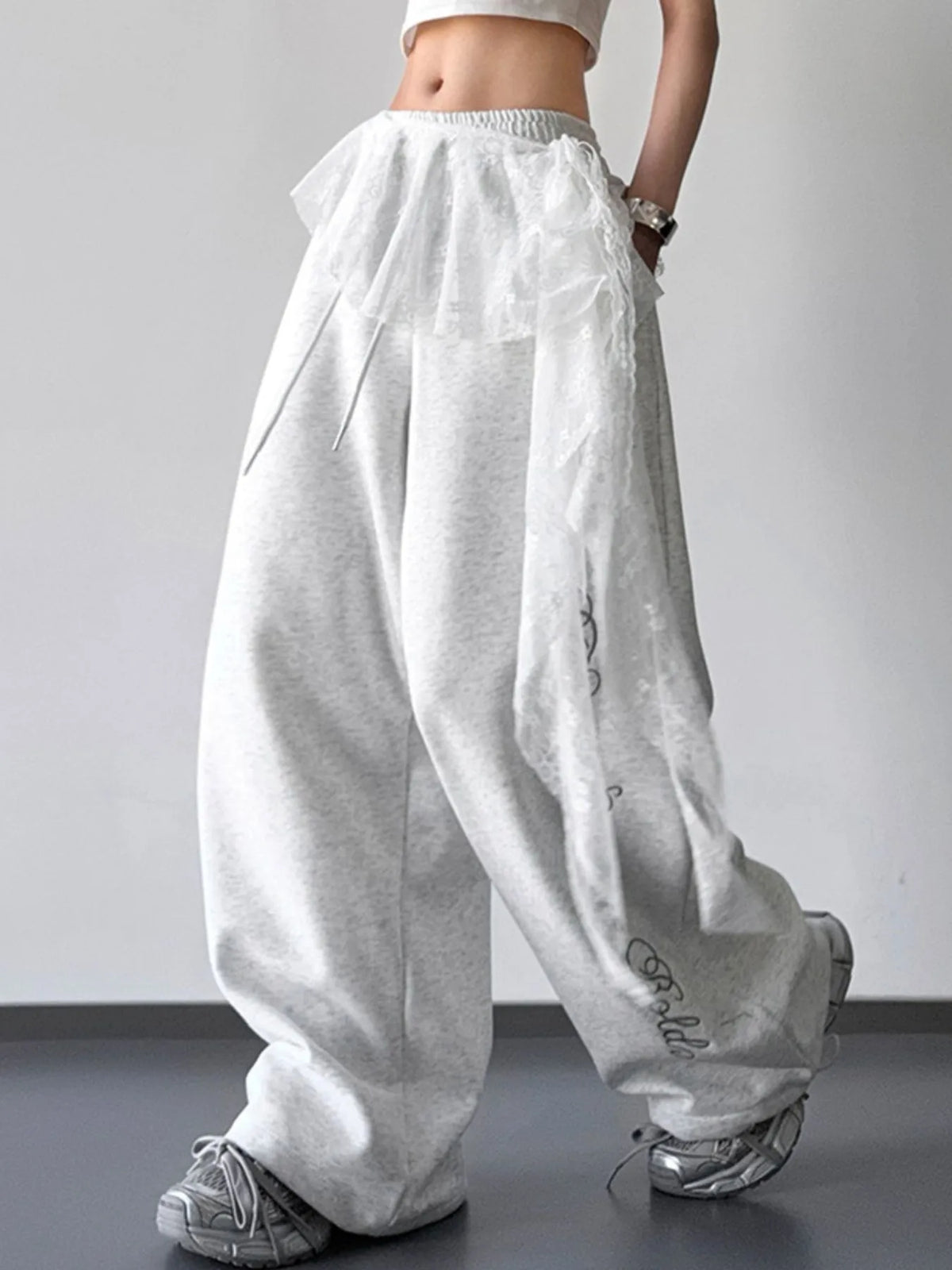 Side view of light gray wide-leg pants with lace overlay