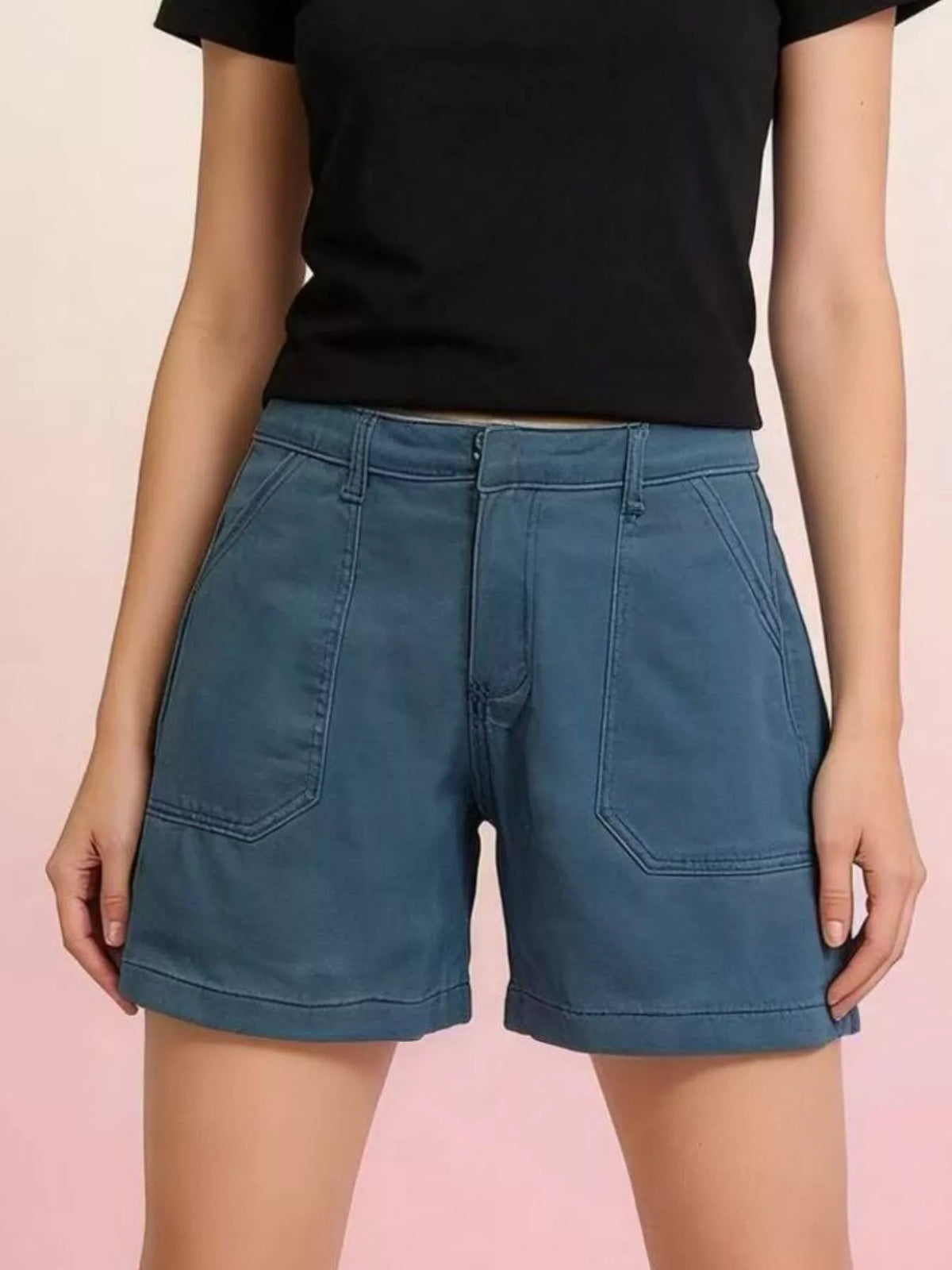 Blue denim shorts with large front patch pockets and stitched hems, front view
