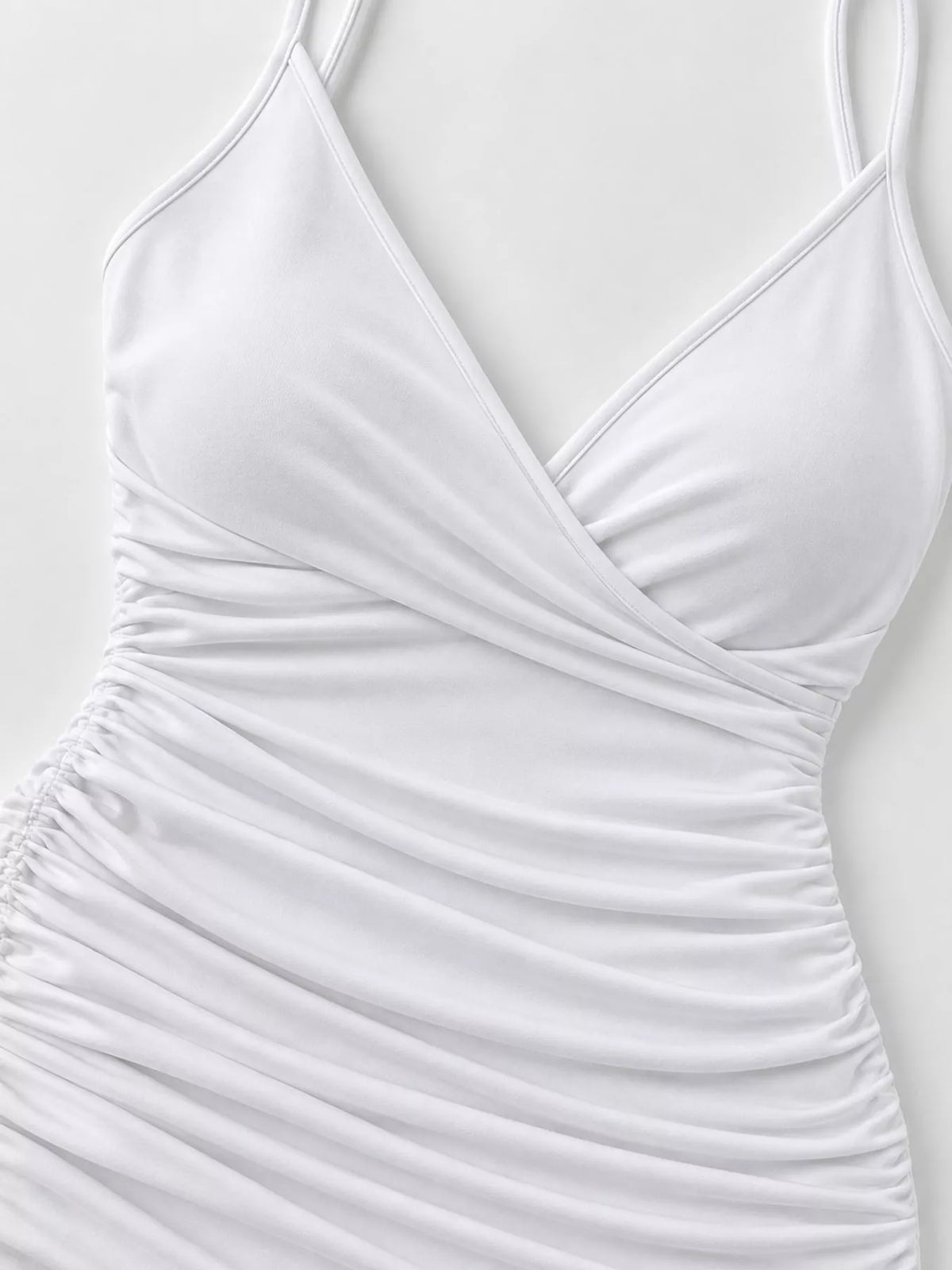 Close view of the white dress's overlapping wrap neckline and gathered bodice.