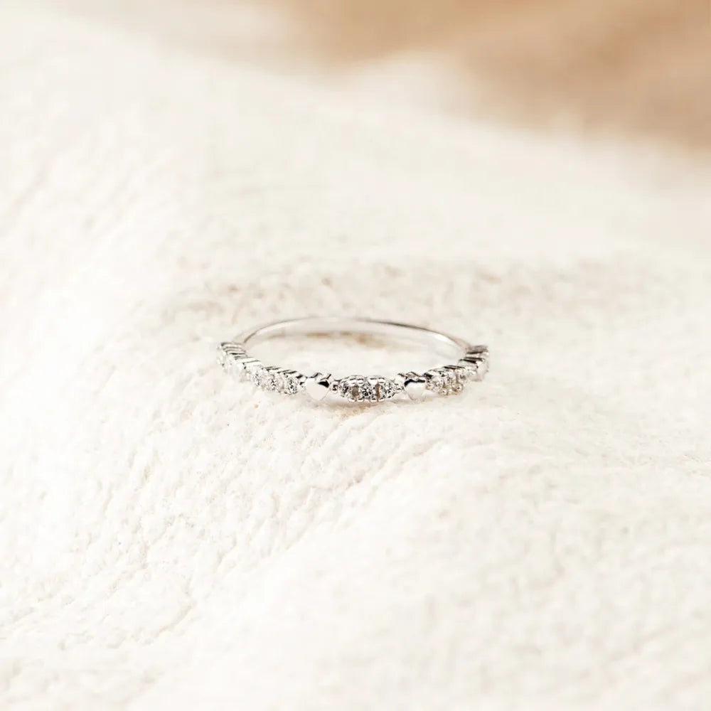 Silver-tone slim zircon band on a light textured surface