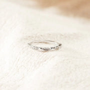 Silver-tone slim zircon band on a light textured surface