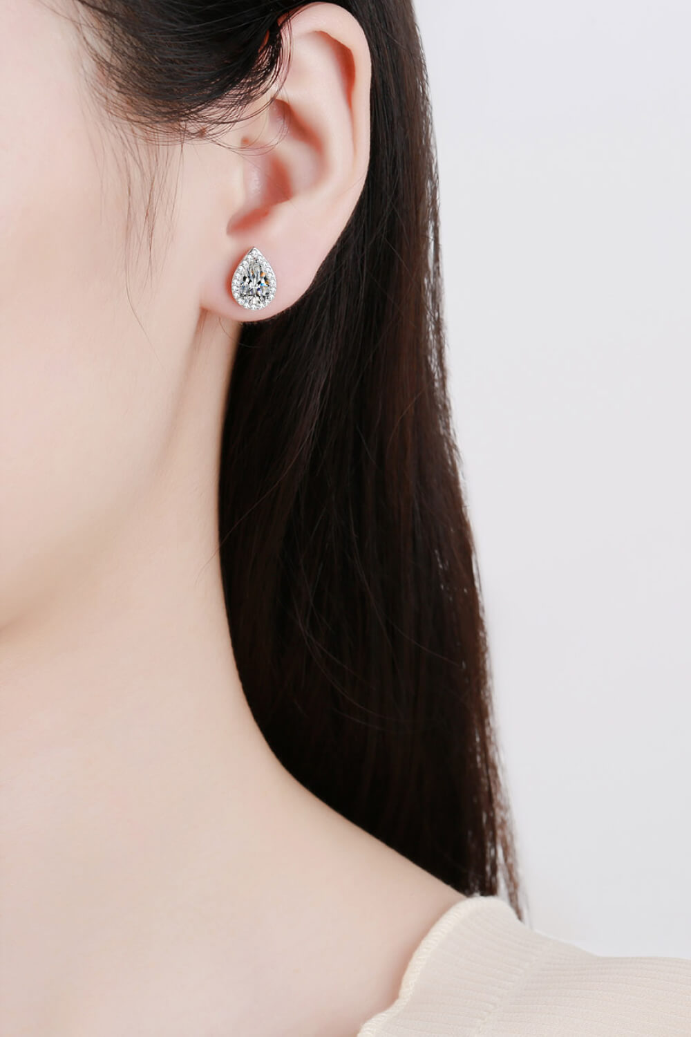 Teardrop stone stud earring worn on an ear