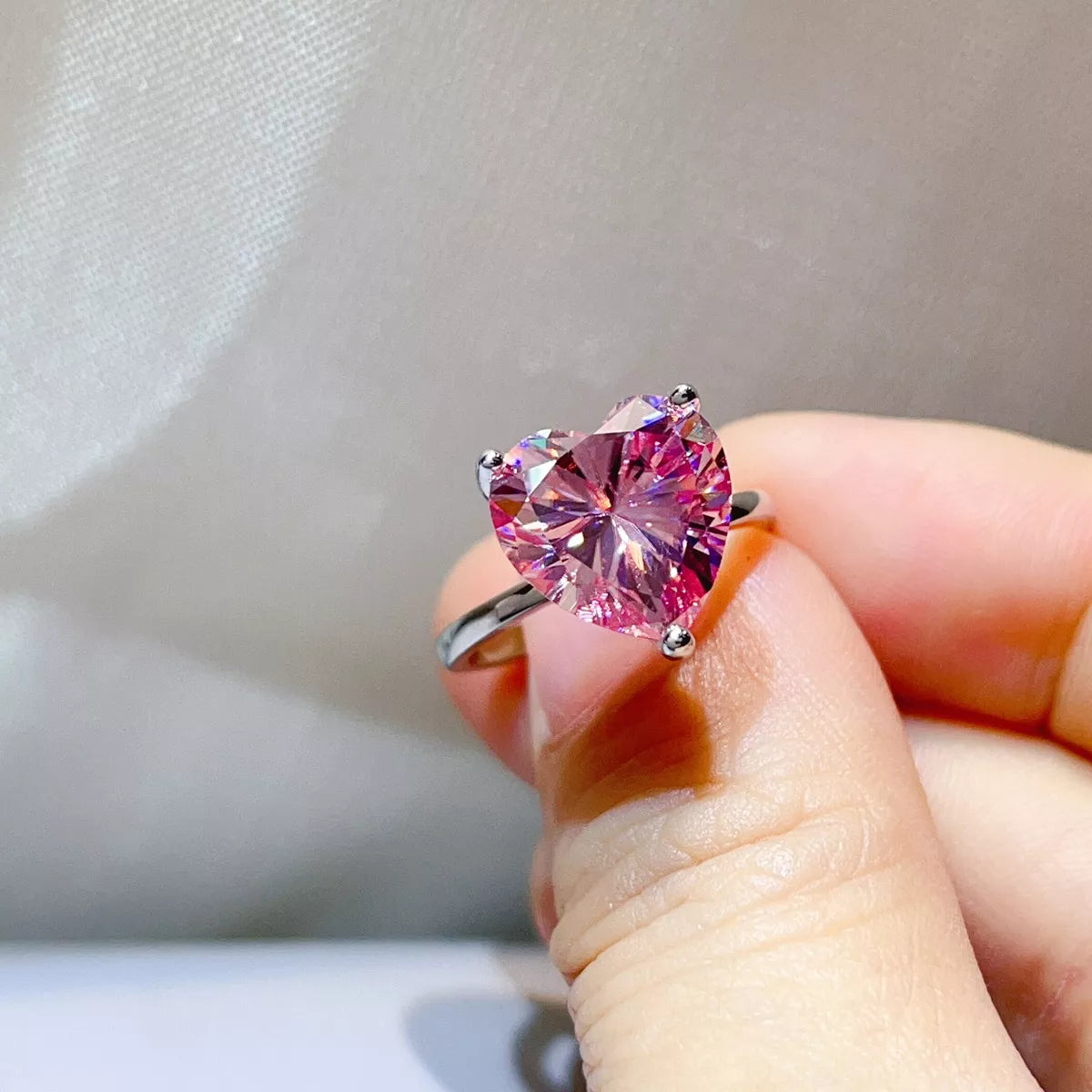 Side view of the pink heart stone above the silver band.