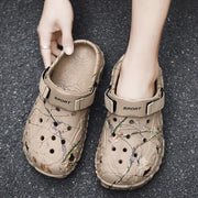 Top view of khaki branch-print clogs showing rounded toes and strap detail