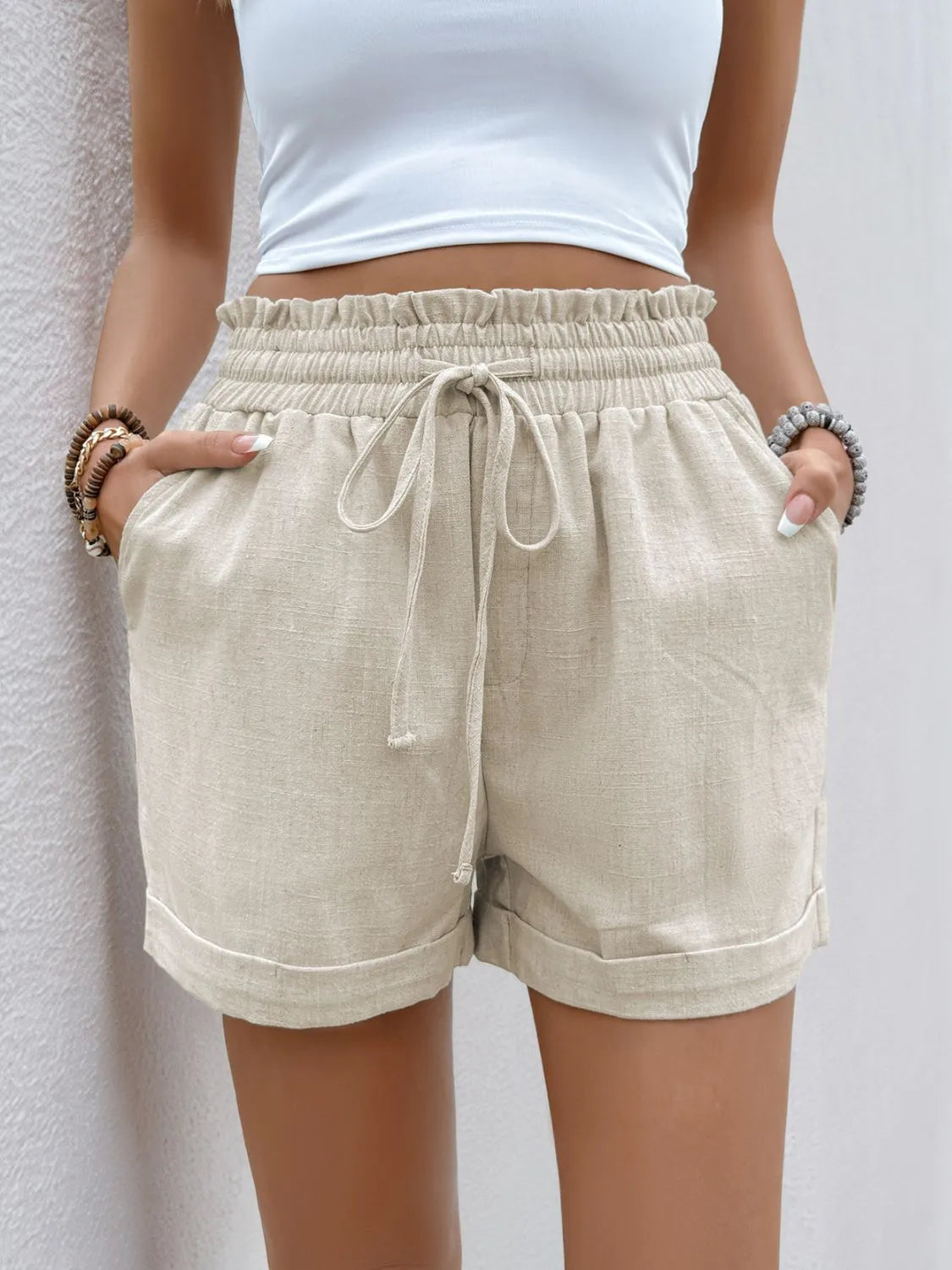 Front view of cream shorts showing ruffled leg hems