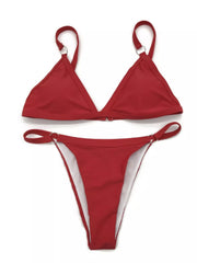 Model wearing a red ring-detail bikini in front of a striped wall