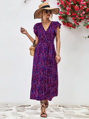 Model wearing a purple printed flutter-sleeve surplice dress, full front view.