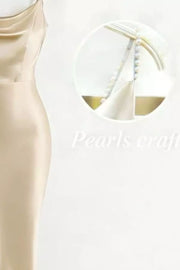 Close detail of pearl shoulder strap against the cream satin dress.