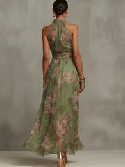 Back view of the green floral maxi dress showing its sleeveless high-neck design.