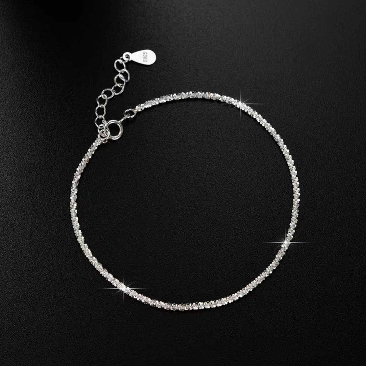 Adjustable sterling silver chain bracelet with extension and clasp on black