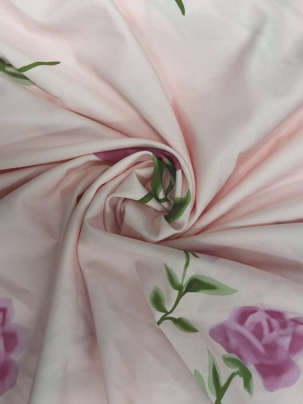 Close-up of pink fabric gathered around a stitched floral motif.