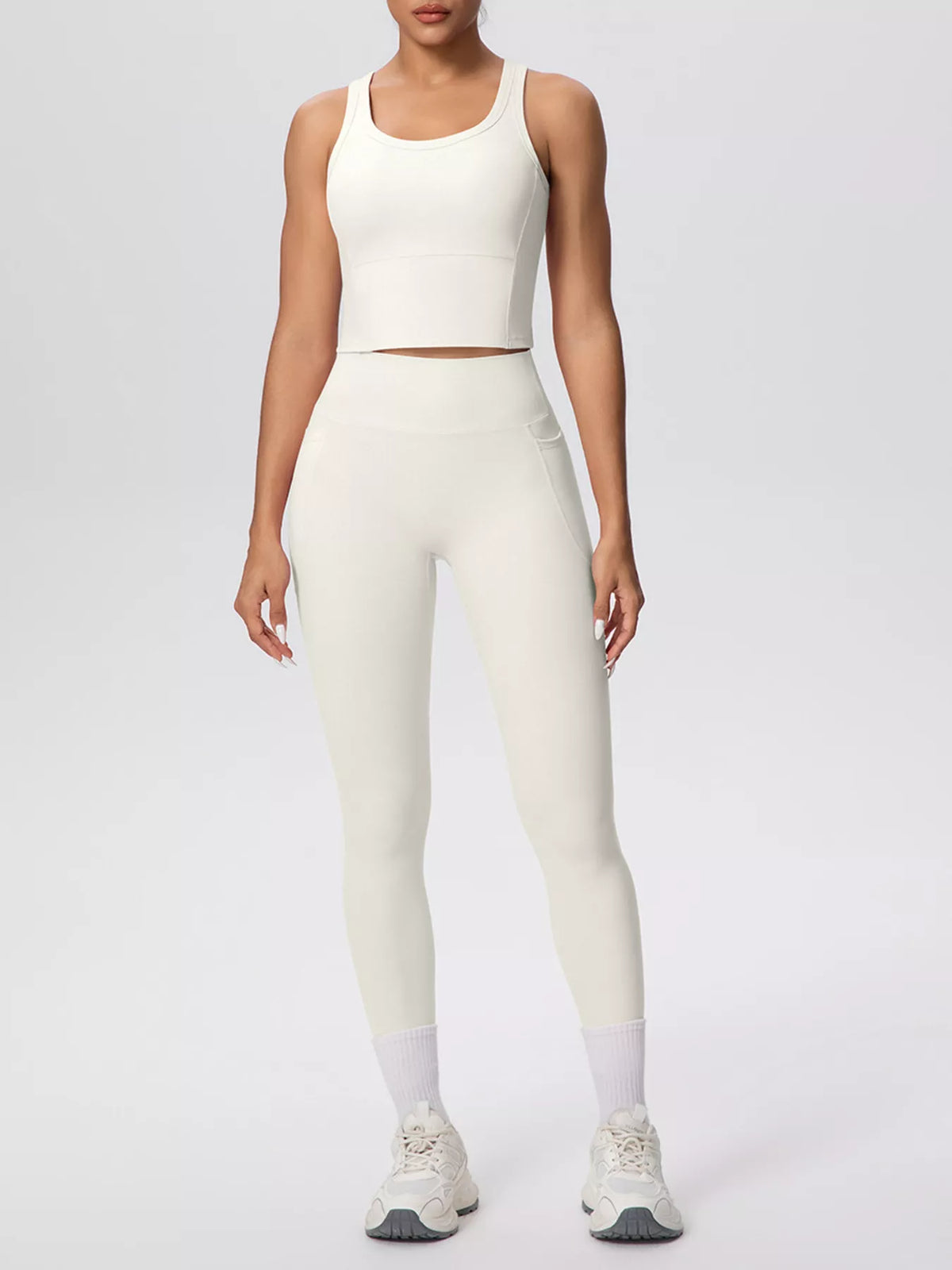 Cream activewear set in a side pose with one arm raised