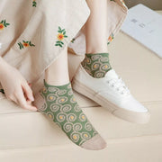 Green spiral-pattern ankle socks worn with white lace-up sneakers