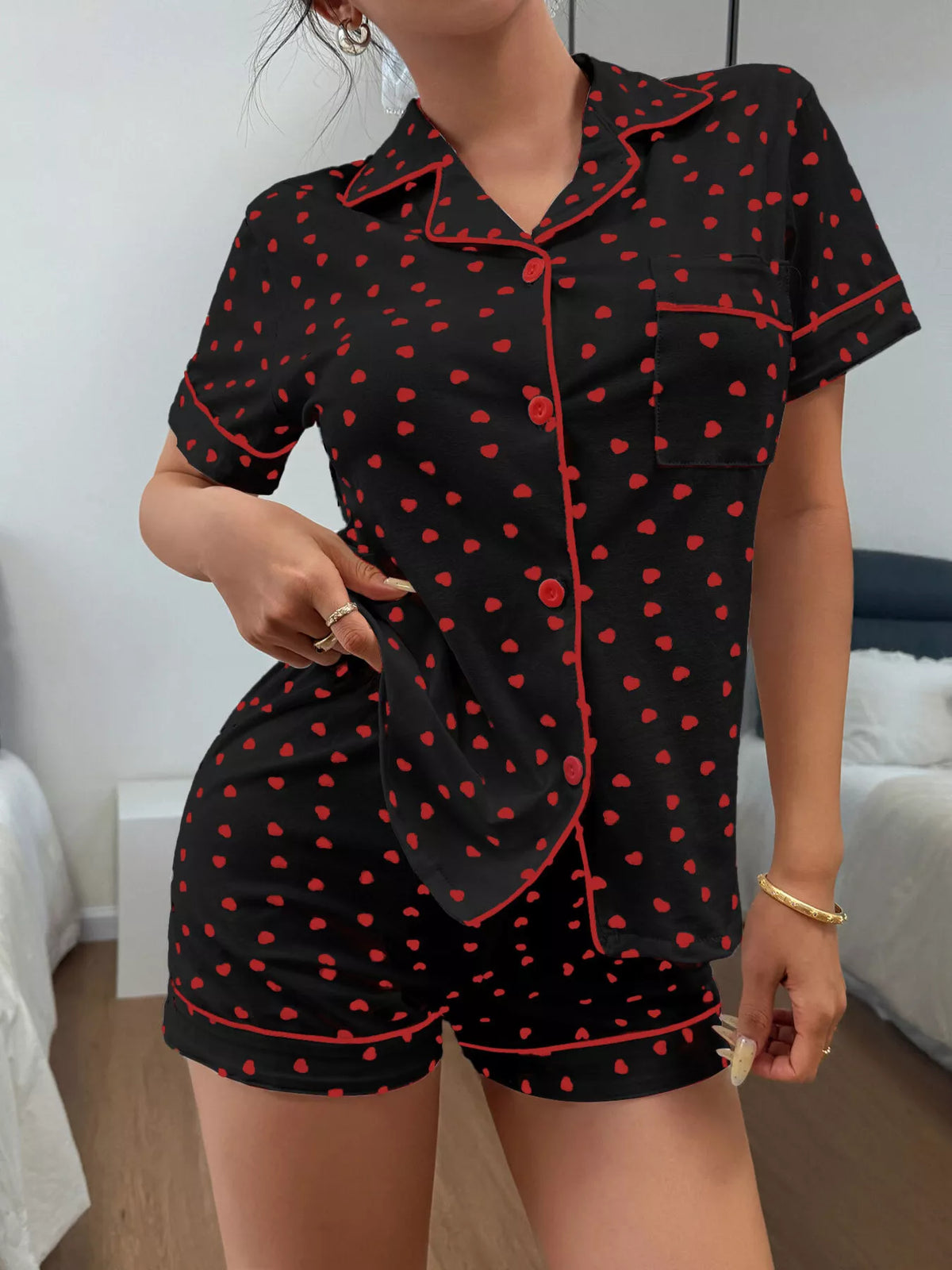 Black pajama shirt and shorts with red heart print and piping, back view
