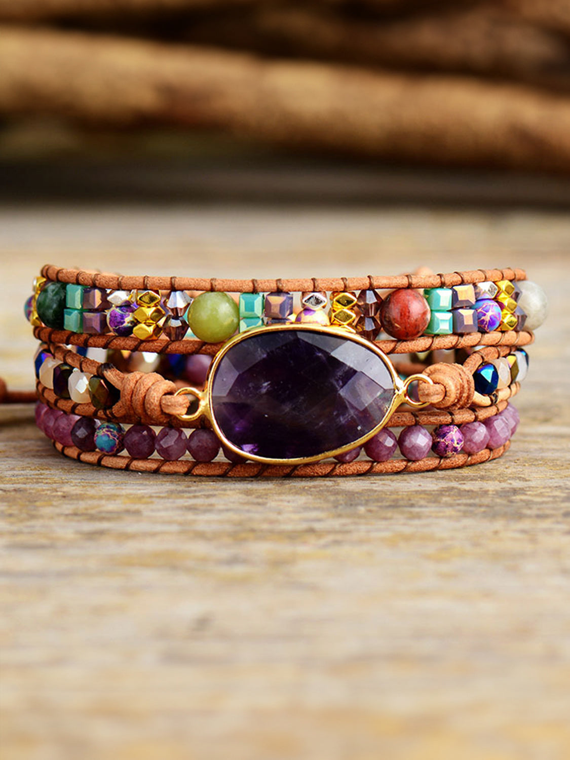 Close front view of a triple-layer bracelet with a large purple oval stone.