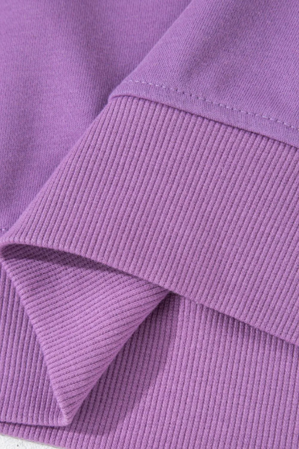 Close-up of purple ribbed sweatshirt cuff