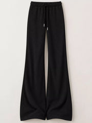 Black drawstring flare trousers displayed flat on white