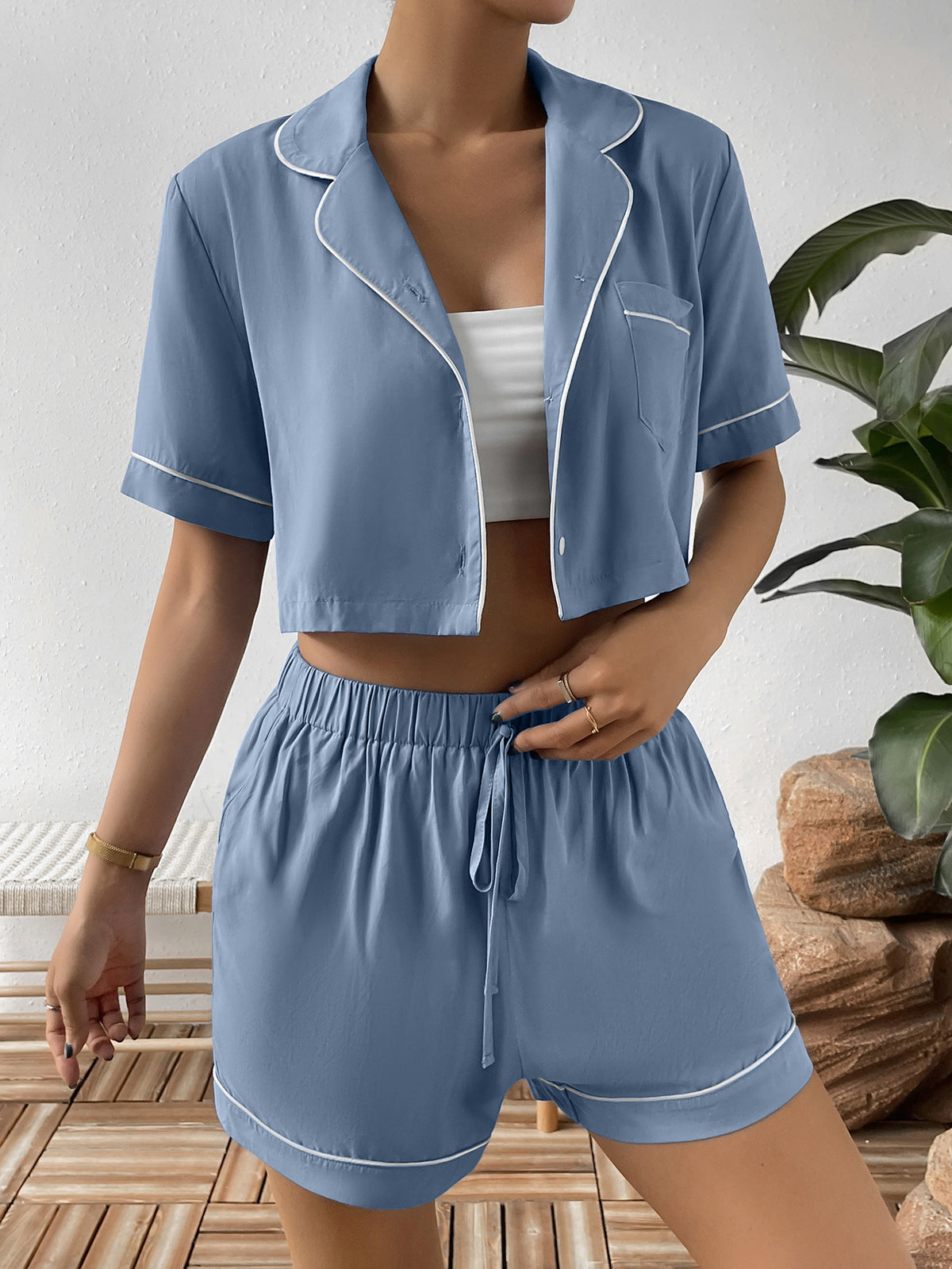 Blue cropped pajama shirt worn open over a white top with matching shorts