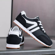 Black sneaker lifted to show its striped side, white sole and gum tread
