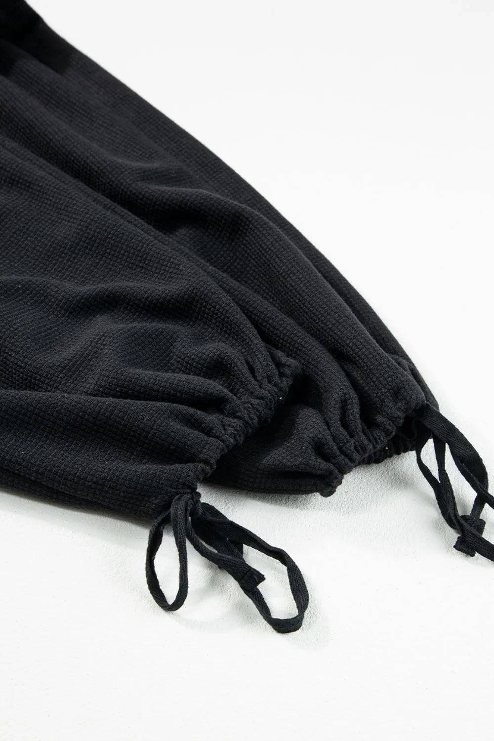 Black jumpsuit ankle hem with adjustable drawstring ties