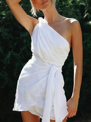 Angled view of white dress showing asymmetric neckline and draped front