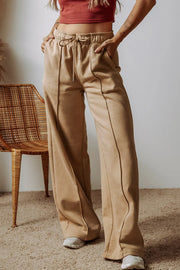 Front view of tan wide-leg pants with an elastic drawstring waist and side pockets.