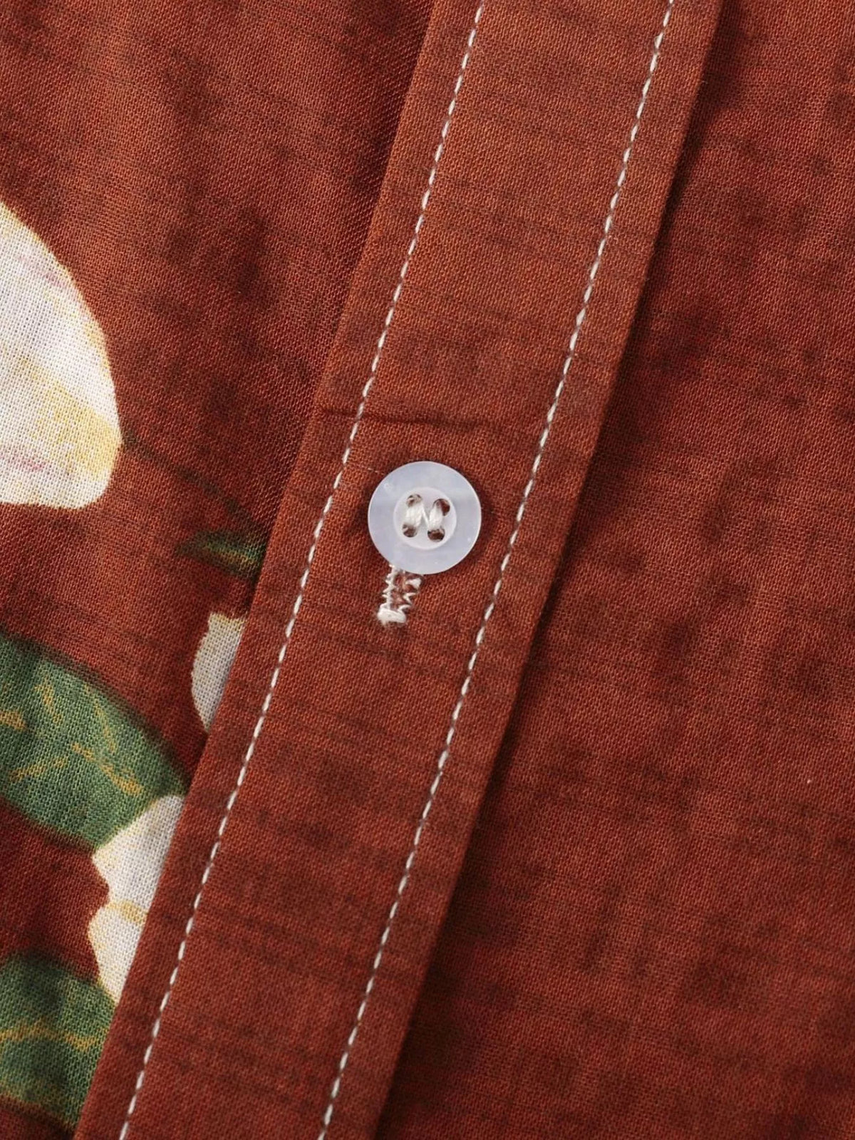 Close-up of rust shirt placket, stitching and button